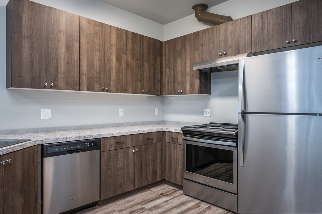 a kitchen with stainless steel appliances and wooden cabinets