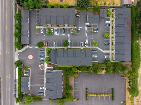 A parking lot with cars and a building in the background.