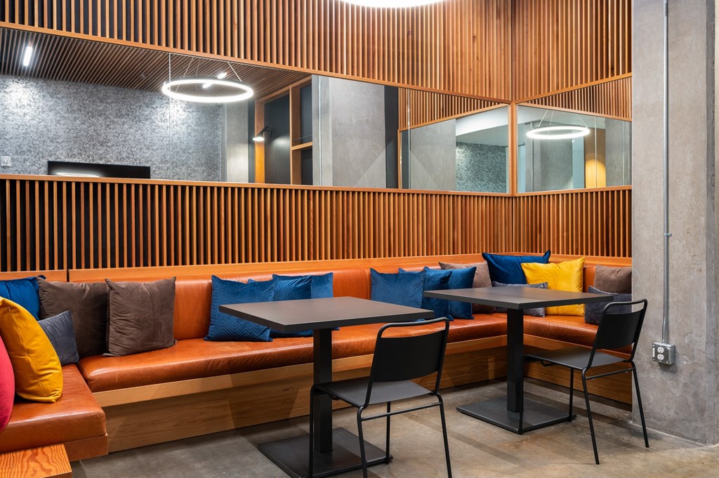 the seating area of a restaurant with tables and couches