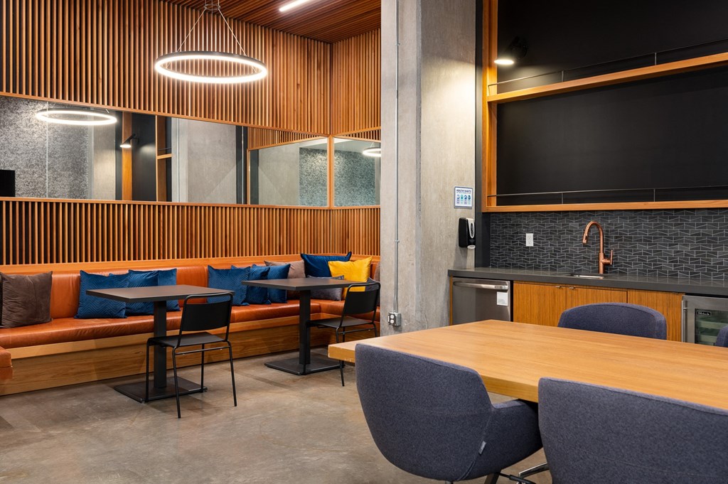 a lounge area with tables and chairs and a television