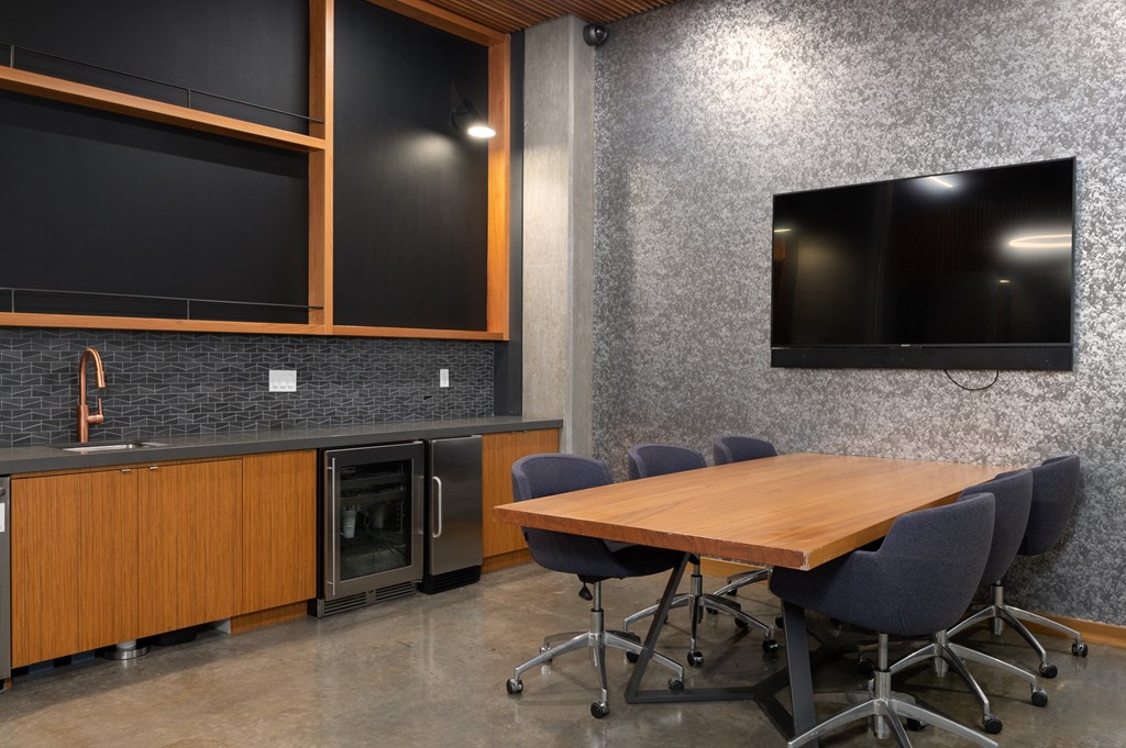 a conference room with a table and chairs and a television