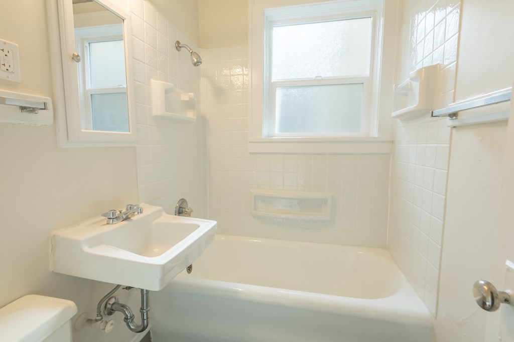 a small bathroom with a sink and a bath tub