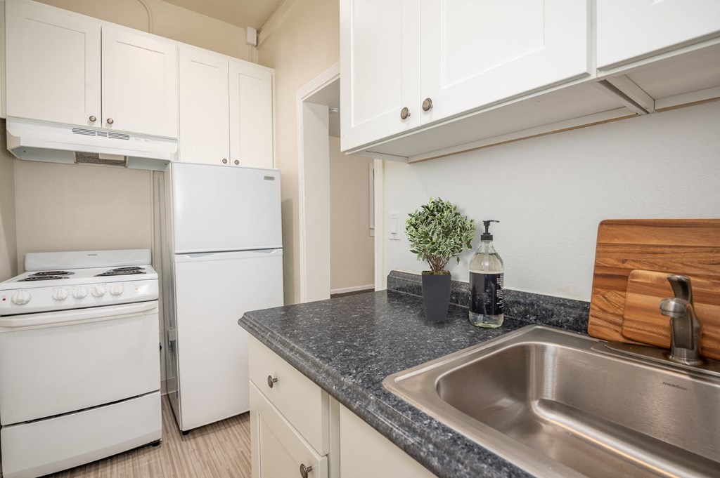a kitchen with white appliances and granite counter tops and a sink