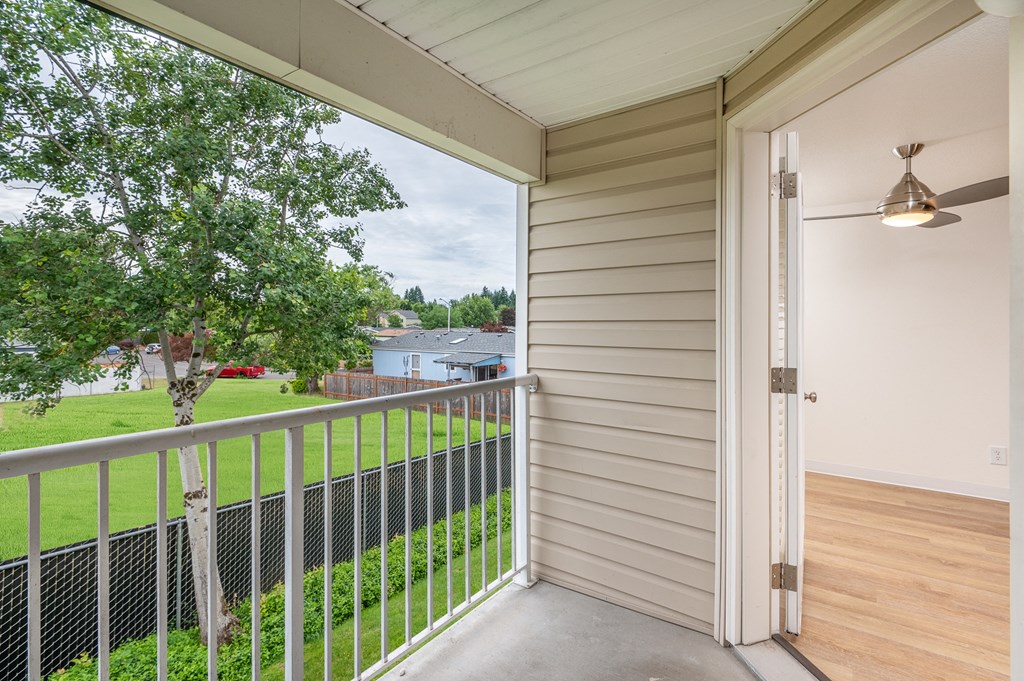 views of the yard from the balcony of a home with a sliding glass door
