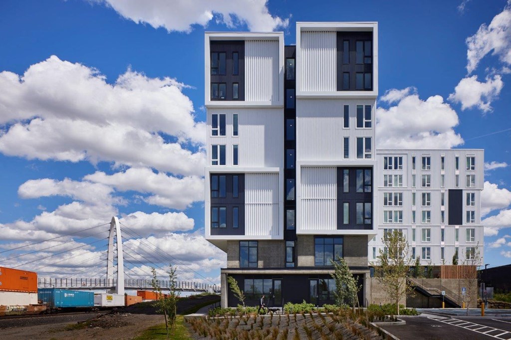 an image of an apartment building with a bridge in the background