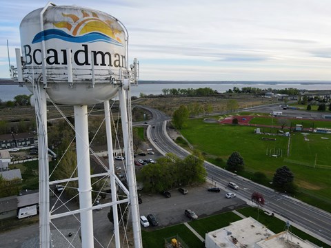 an aerial view of a water tower overlooking a highway and the ocean