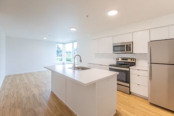a large kitchen with white cabinets and stainless steel appliances