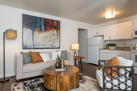 A living room with a couch, a coffee table, and a painting on the wall.