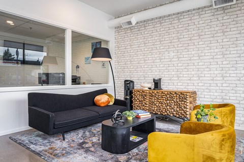 a living room with a black couch and yellow chairs