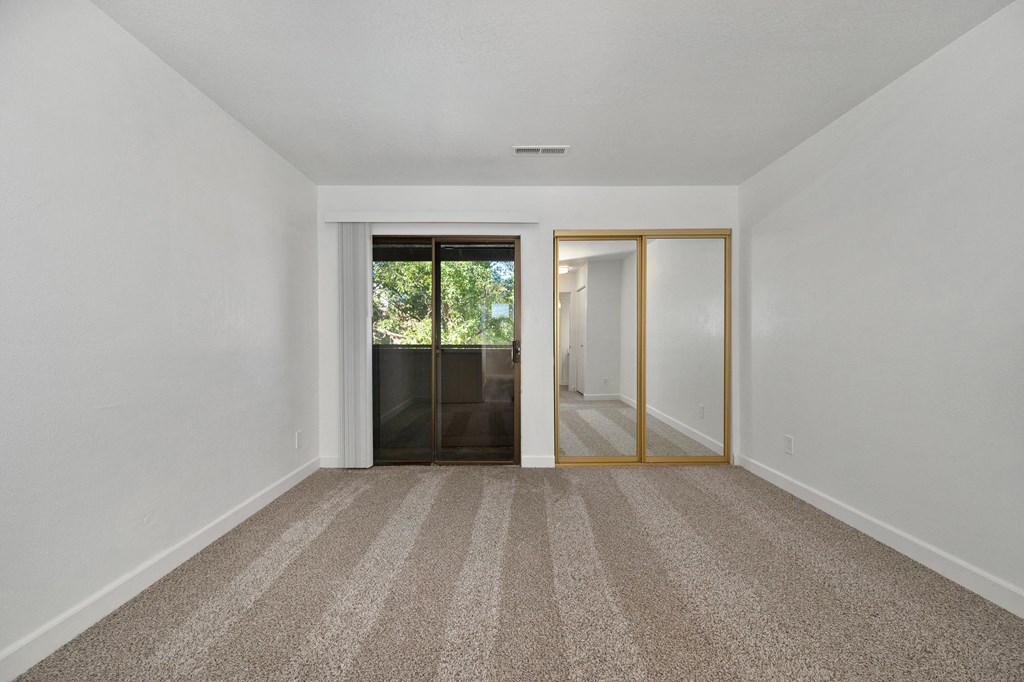 2 BR Apartments in Tracy CA - Townhomes at 201 - Bedroom with Carpet Flooring, Oversized Closet, and Access to Patio/Balcony