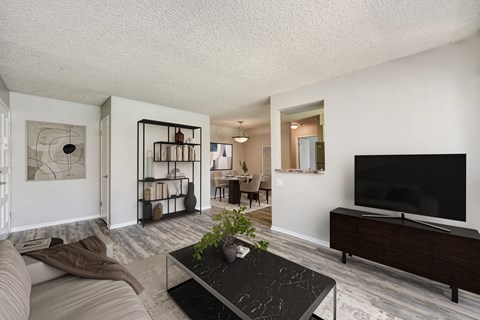 A living room with a black coffee table and a flat screen TV.