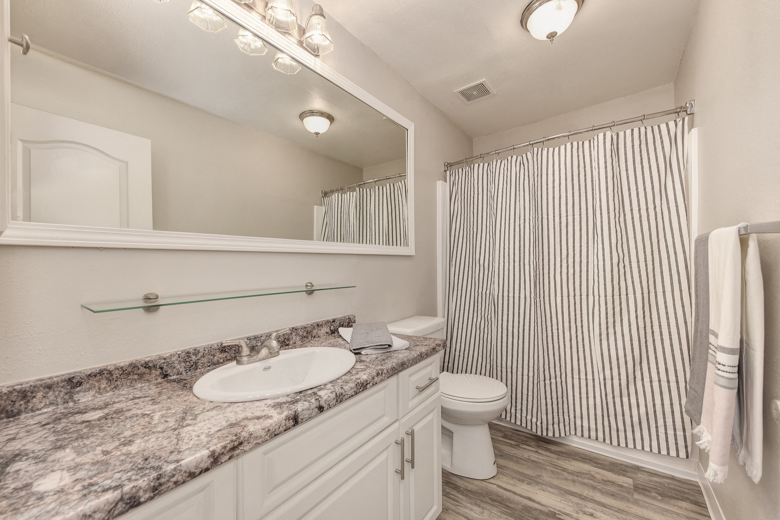 Bathroom with large mirror and white cabinetry