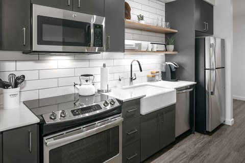 a kitchen with stainless steel appliances and black and white cabinets