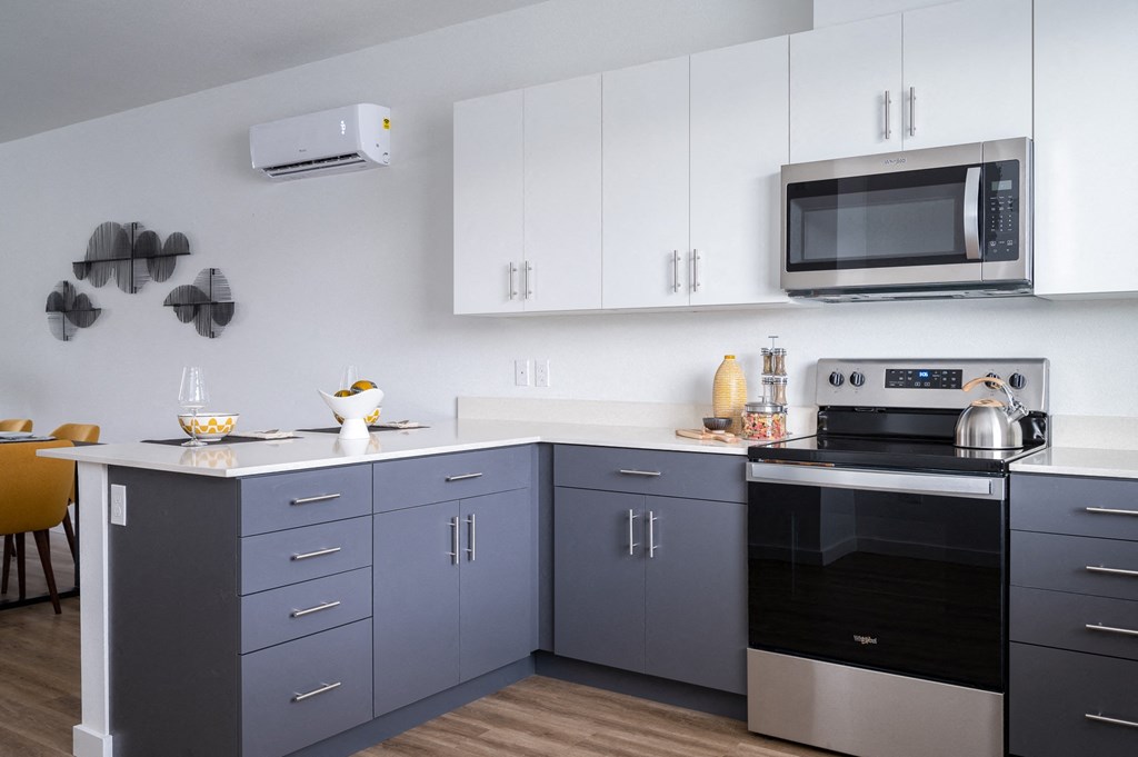 a kitchen with gray cabinets and a white countertop