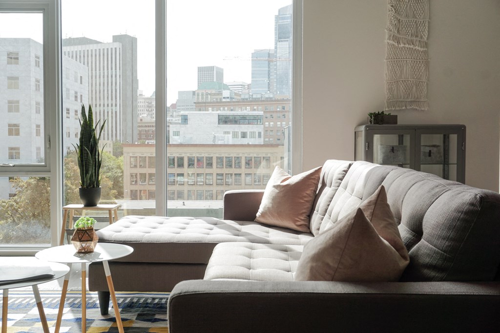 a living room with a couch and a view of the city