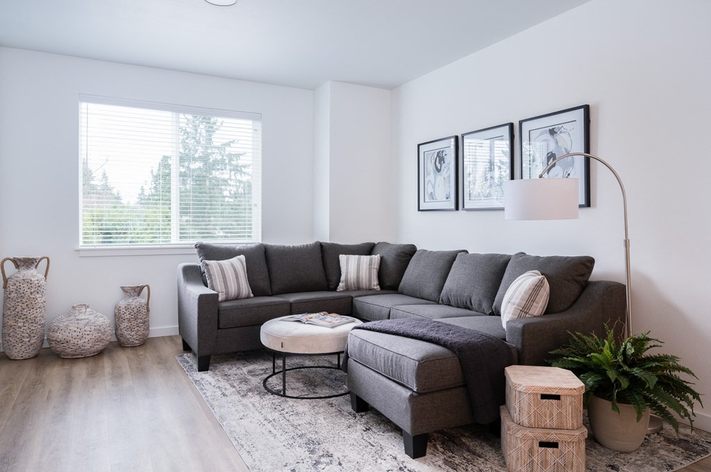 3 BR Apartments in Oregon City OR - Timberview Apartments and Townhomes - Living Room with Stylish Decor, a Large Window, White Walls, and Wood-Style Flooring