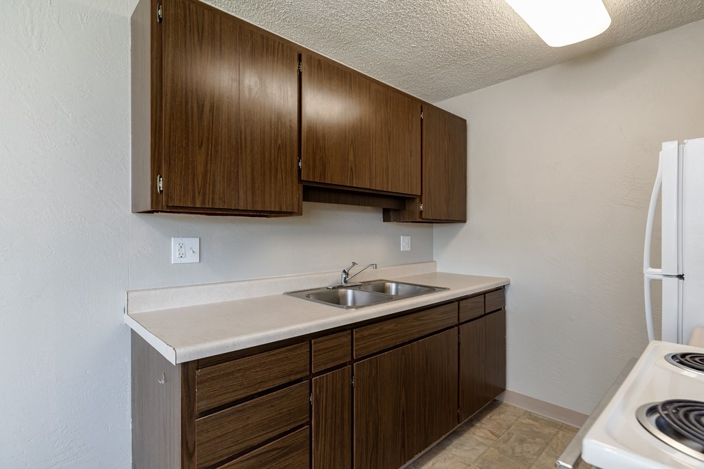 A kitchen with brown cabinets and a white stove.