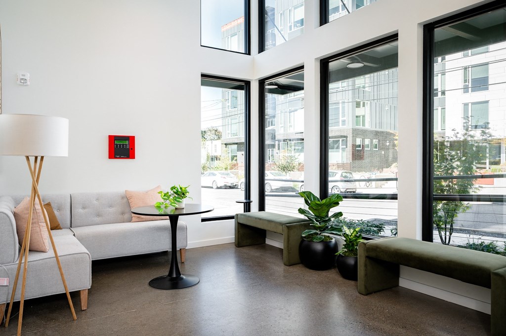 a living room with couches and a table and large windows