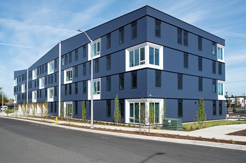 A modern blue building with white trim and windows.
