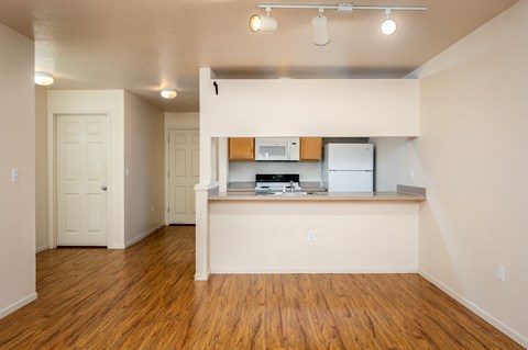 A kitchen with white cabinets and a wooden floor.