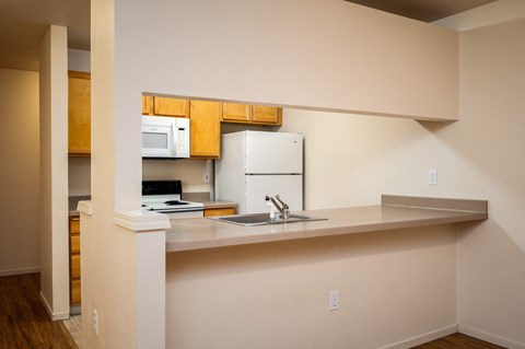 A kitchen with a microwave and a refrigerator mounted on the wall.