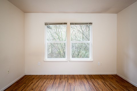 A room with a window and wooden floors.