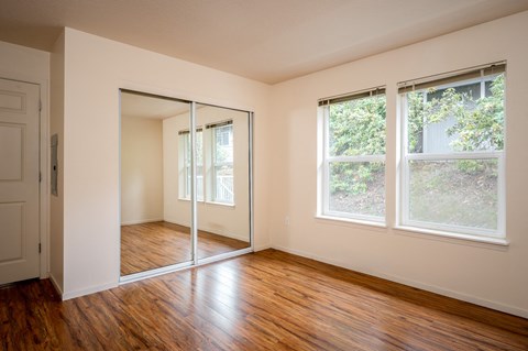 A room with a sliding glass door and wooden floors.