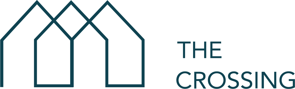 A graphic with three houses and the words "The Crossing" written to the right.