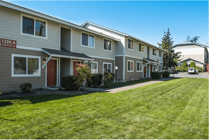 a row of houses with a grassy yard in front of them