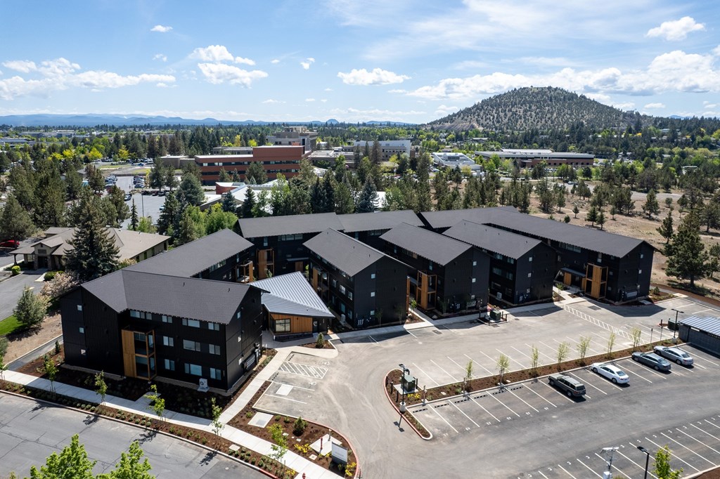 A large building complex with a parking lot in front.