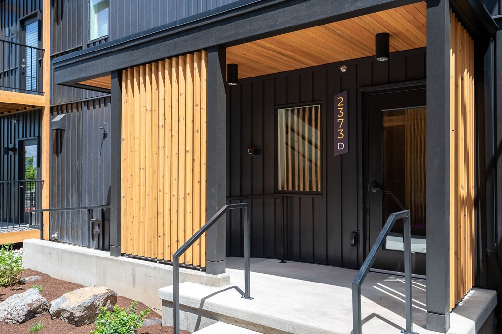 A black and wooden building with the number 2373D on the door.