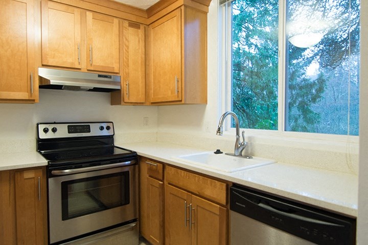 a kitchen with wooden cabinets and a sink and a window