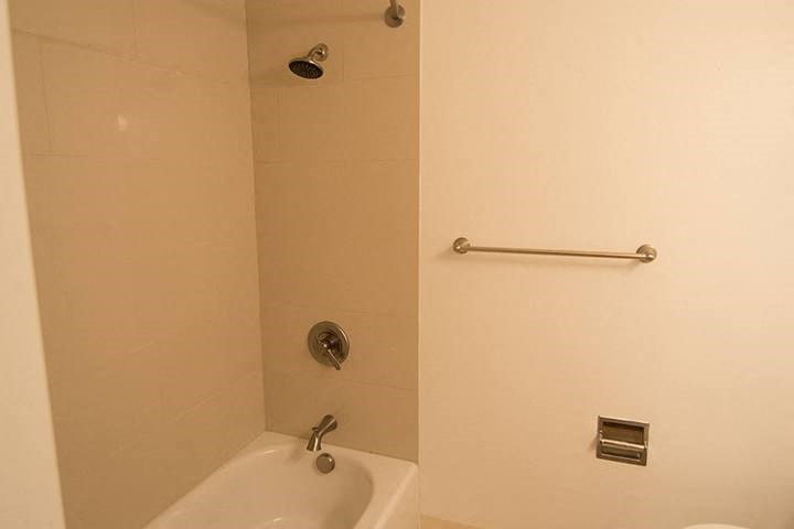 a white bathroom with a shower and a sink