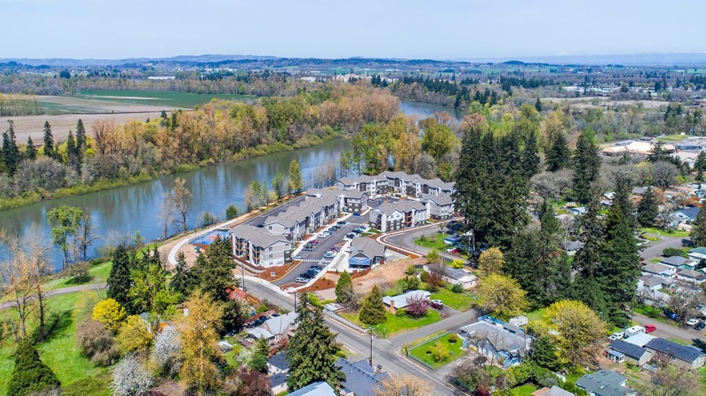 A bird's eye view of The Banks Apartments with a river and trees in the background.
