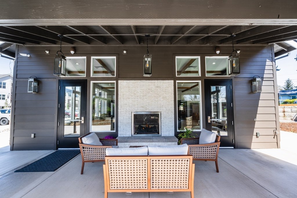A patio with a fireplace and chairs.