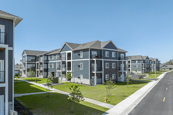 A row of modern townhouses with a clear blue sky above.