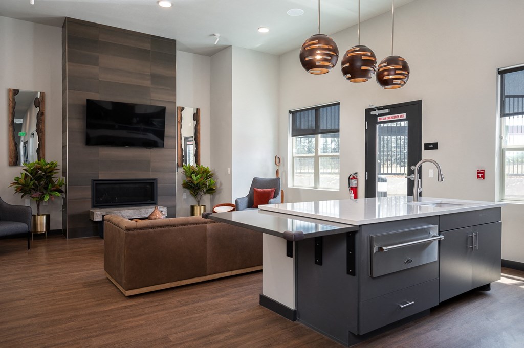 a kitchen with a large island in the middle of a room with a couch and a fireplace