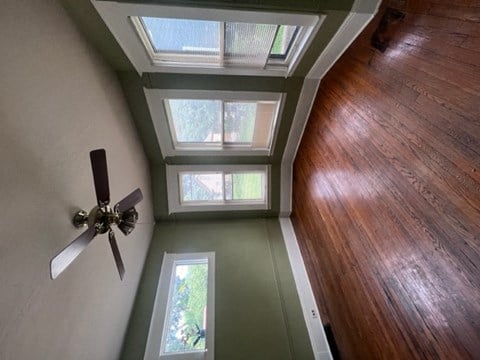 a living room with a ceiling fan and wood floors