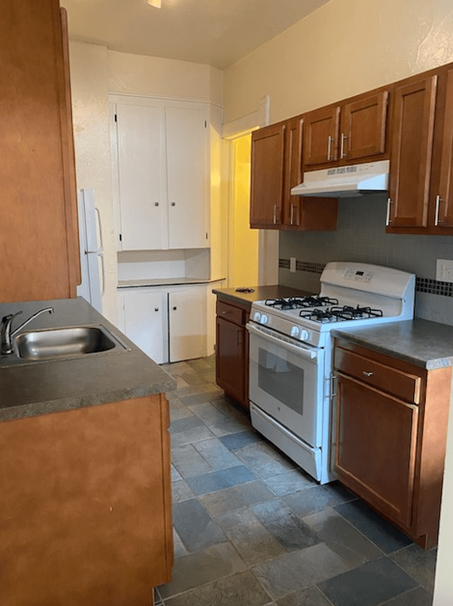 a kitchen with a white stove top oven next to a sink
