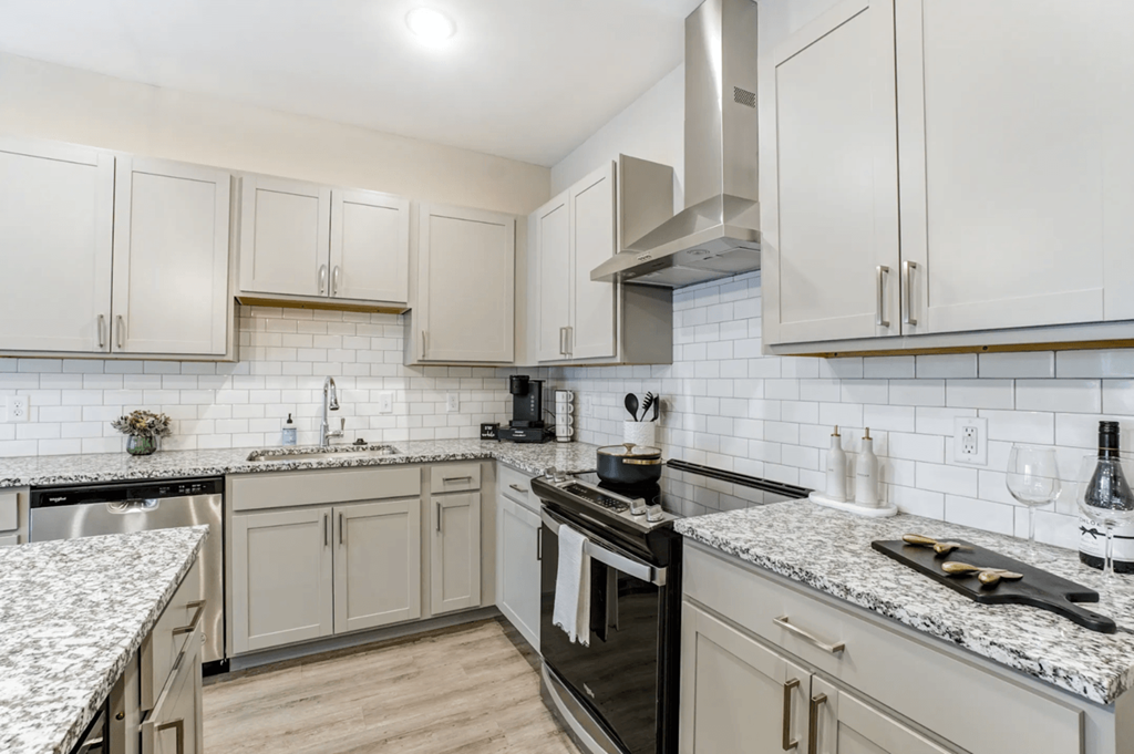 A kitchen with a black stove top oven and white cabinets.