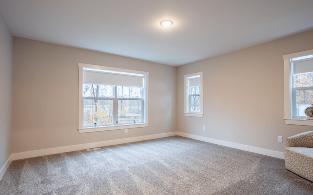 A room with two windows and a carpeted floor.