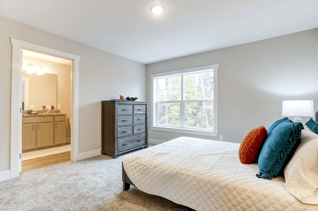 A bedroom with a large bed and a dresser.