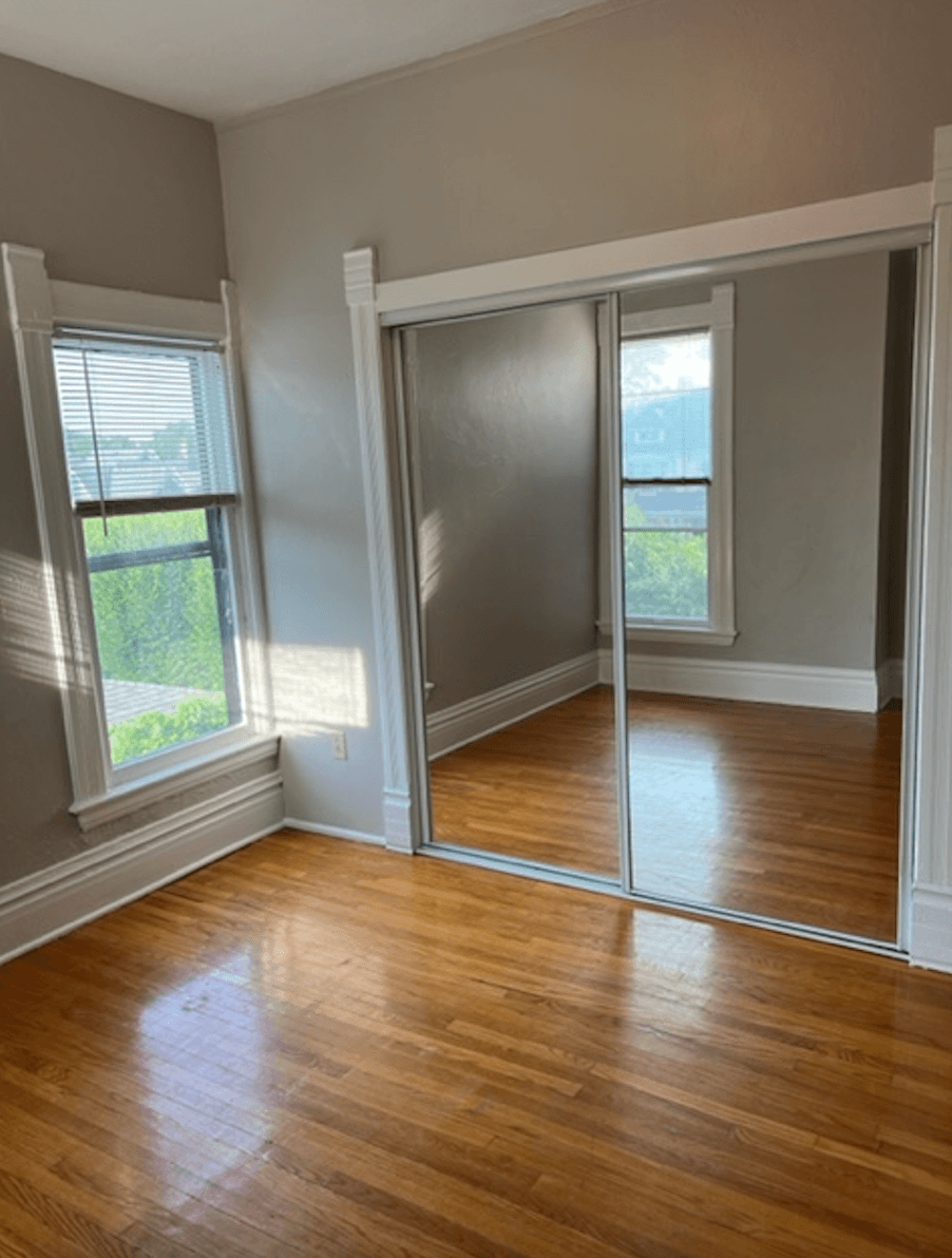 an empty living room with sliding glass doors and a hard wood floor