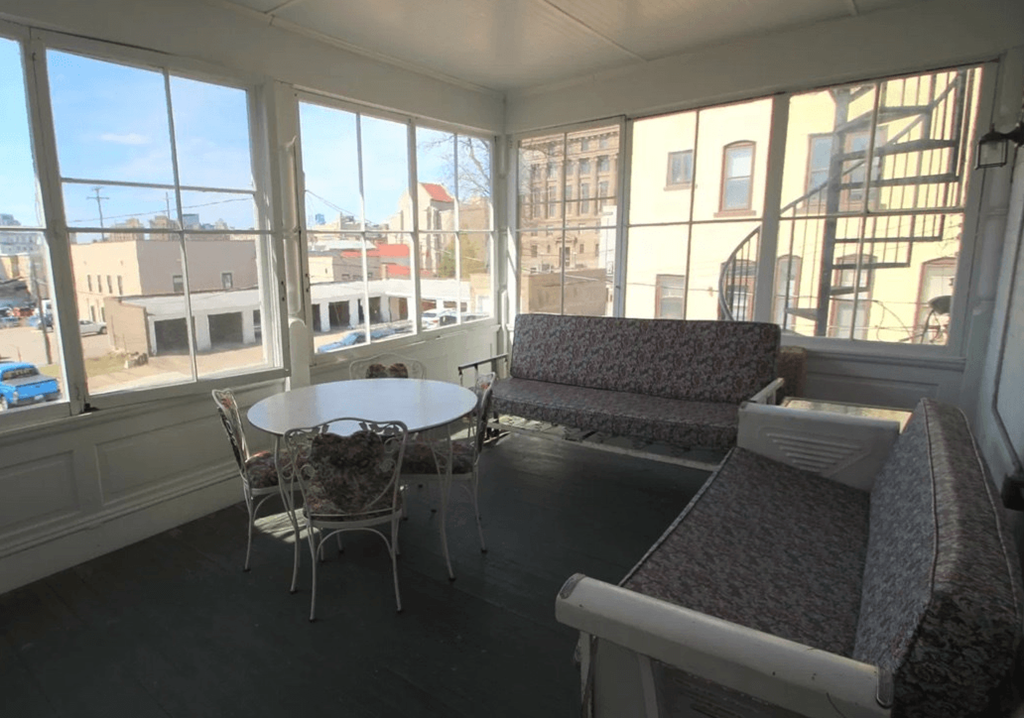 a large screened in porch with a table and chairs