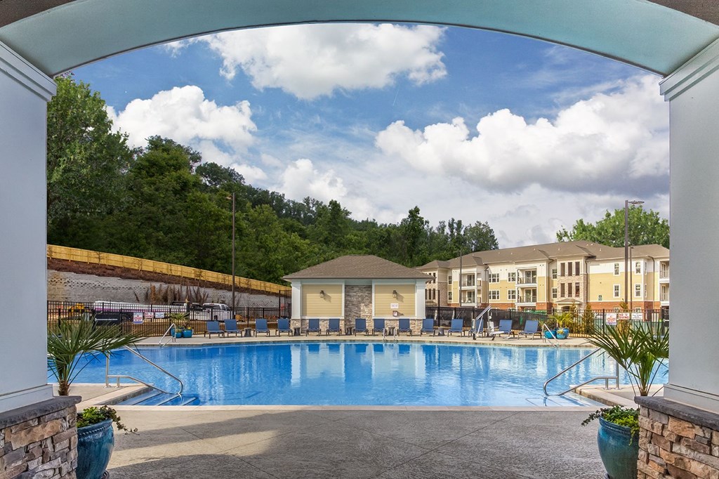 A large swimming pool surrounded by a stone wall and a white pillar at Crabtree Lakeside Apartments, North Carolina