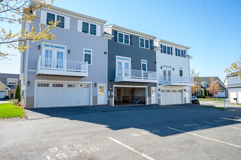 A two-story building with a garage and a balcony on the second floor.