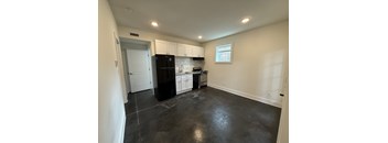 A kitchen with black appliances and white cabinets.