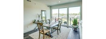a dining room with a large window and a table with chairs