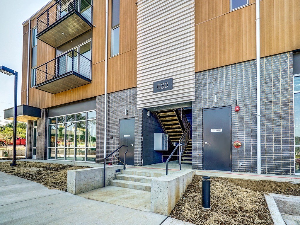 a brick building with stairs and a glass door