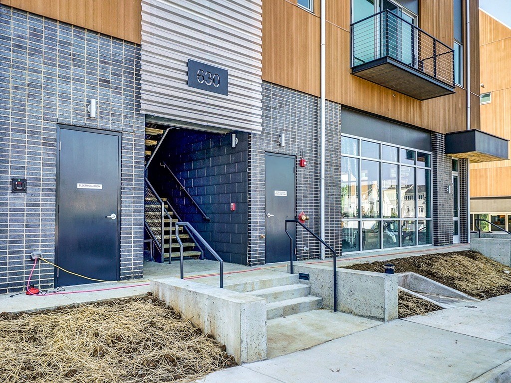 a building with two doors and some hay in front of it